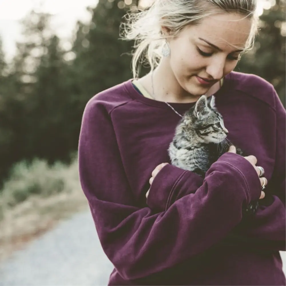 Femme tenant son chat contre elle – SoCat, marque de friandises pour chat par RIGA